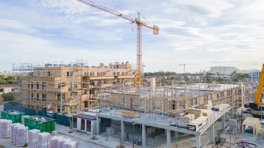 Foto de un bloque de viviendas en obras para ilustrar el artículo sobre el coste de mudarse en España en 2026